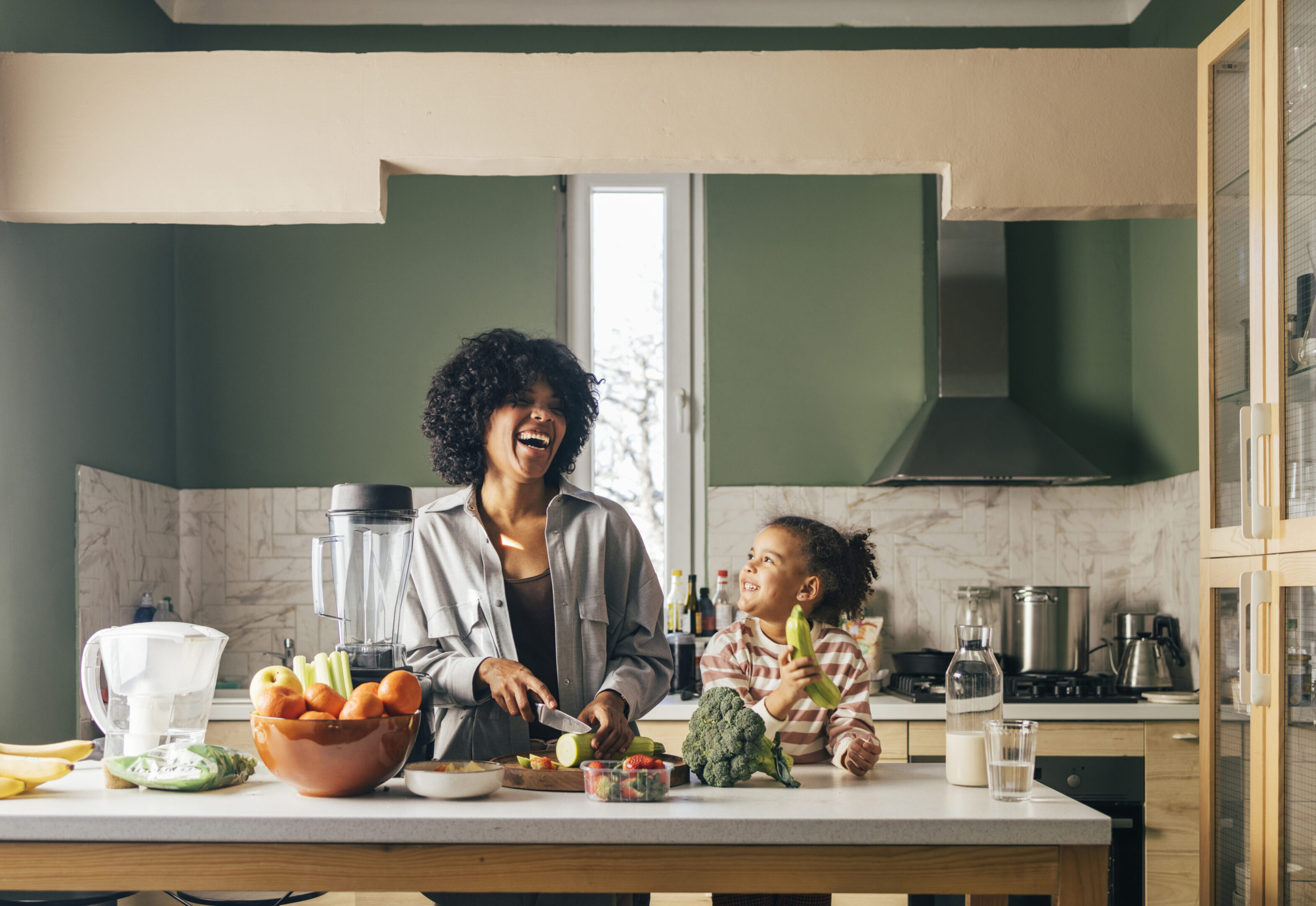 Mother and daughter cooking together, smiling happily.