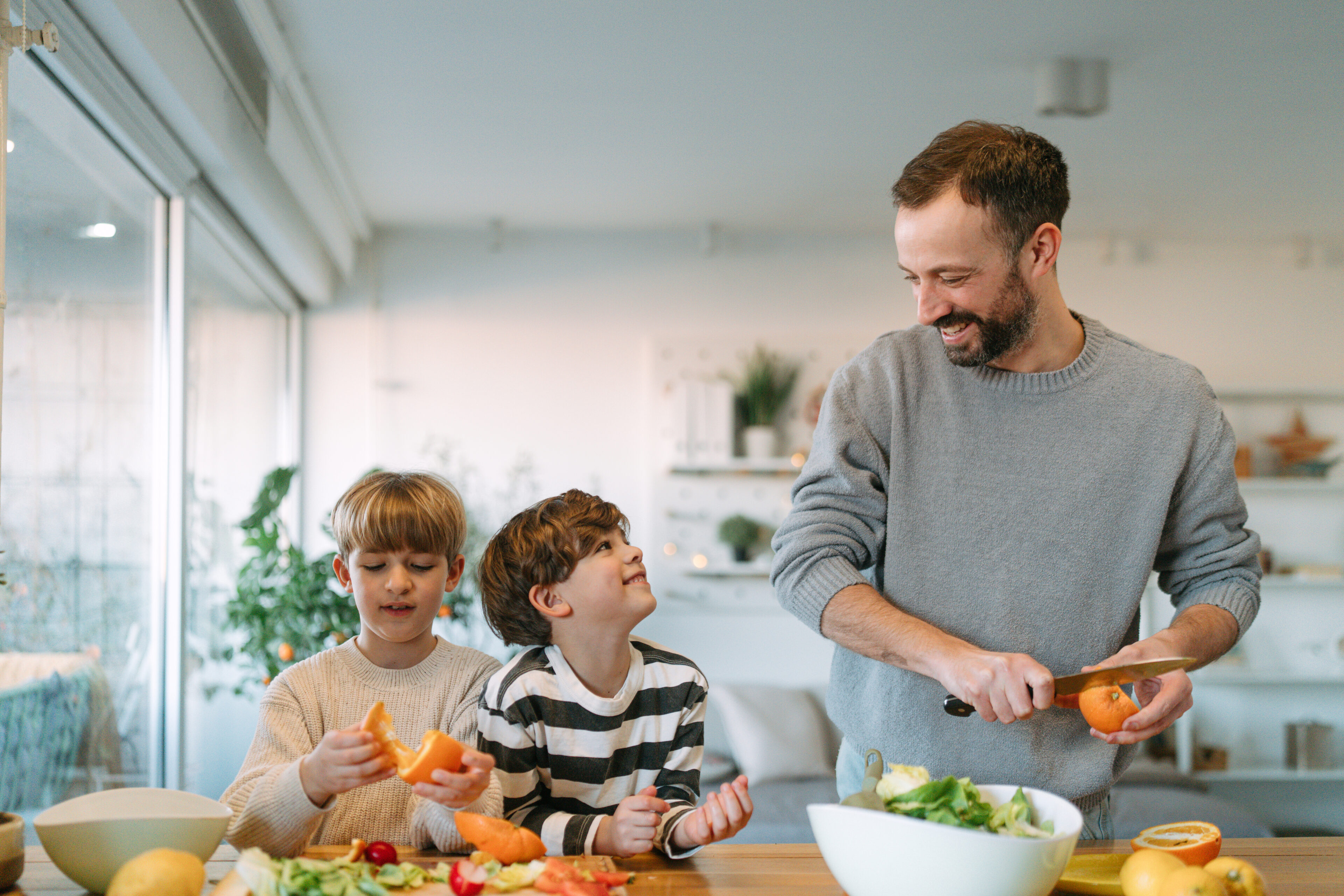 Father and sons cooking together in kitchen.