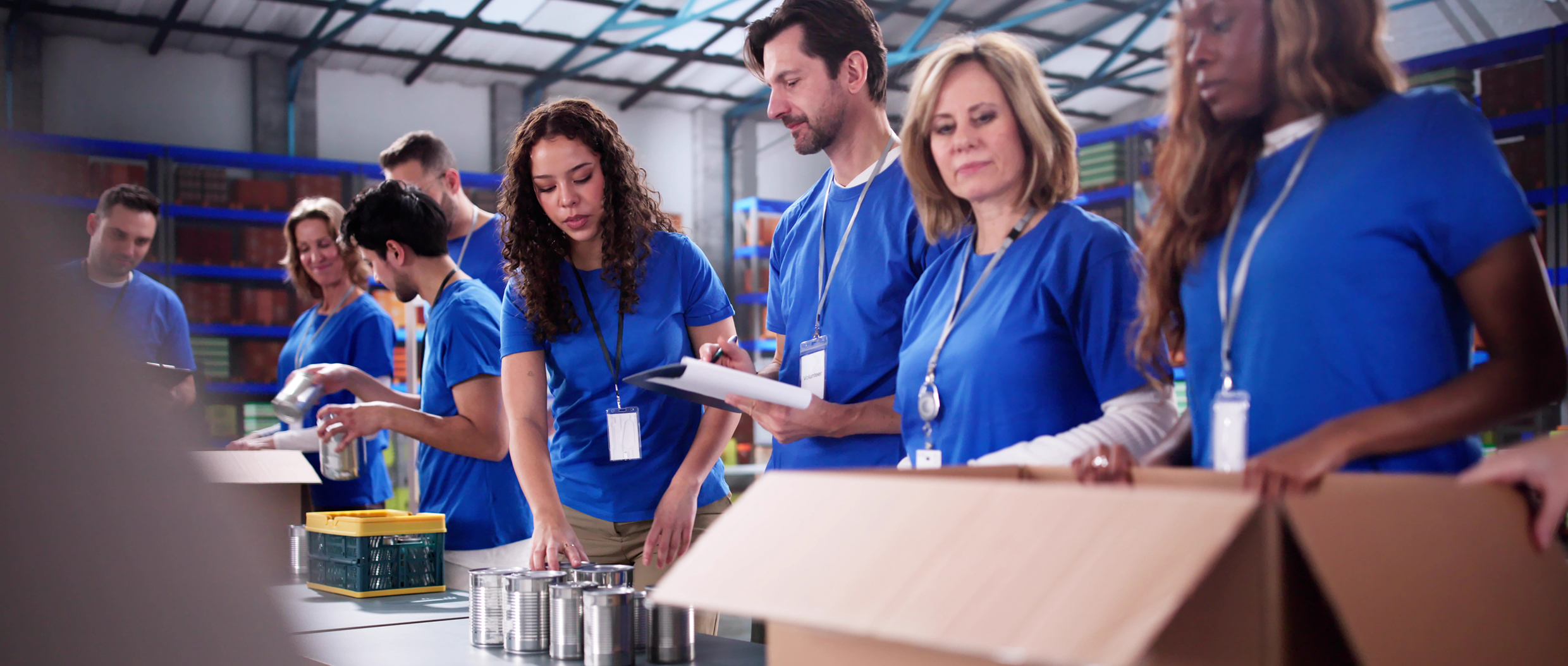 Volunteers packing food in a warehouse.